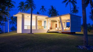 A modern, two-story house with a flat roof and large windows, surrounded by palm trees and a well-maintained lawn. - Ocean View Luxury Escape Lombok Villa 1133 (Lombok)