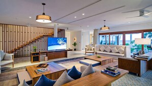 Una sala de estar moderna con televisor, sofá, mesa de centro y una escalera.
