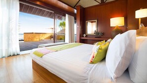 Une chambre d’hôtel avec un grand lit, une vue sur la plage et un plancher en bois.