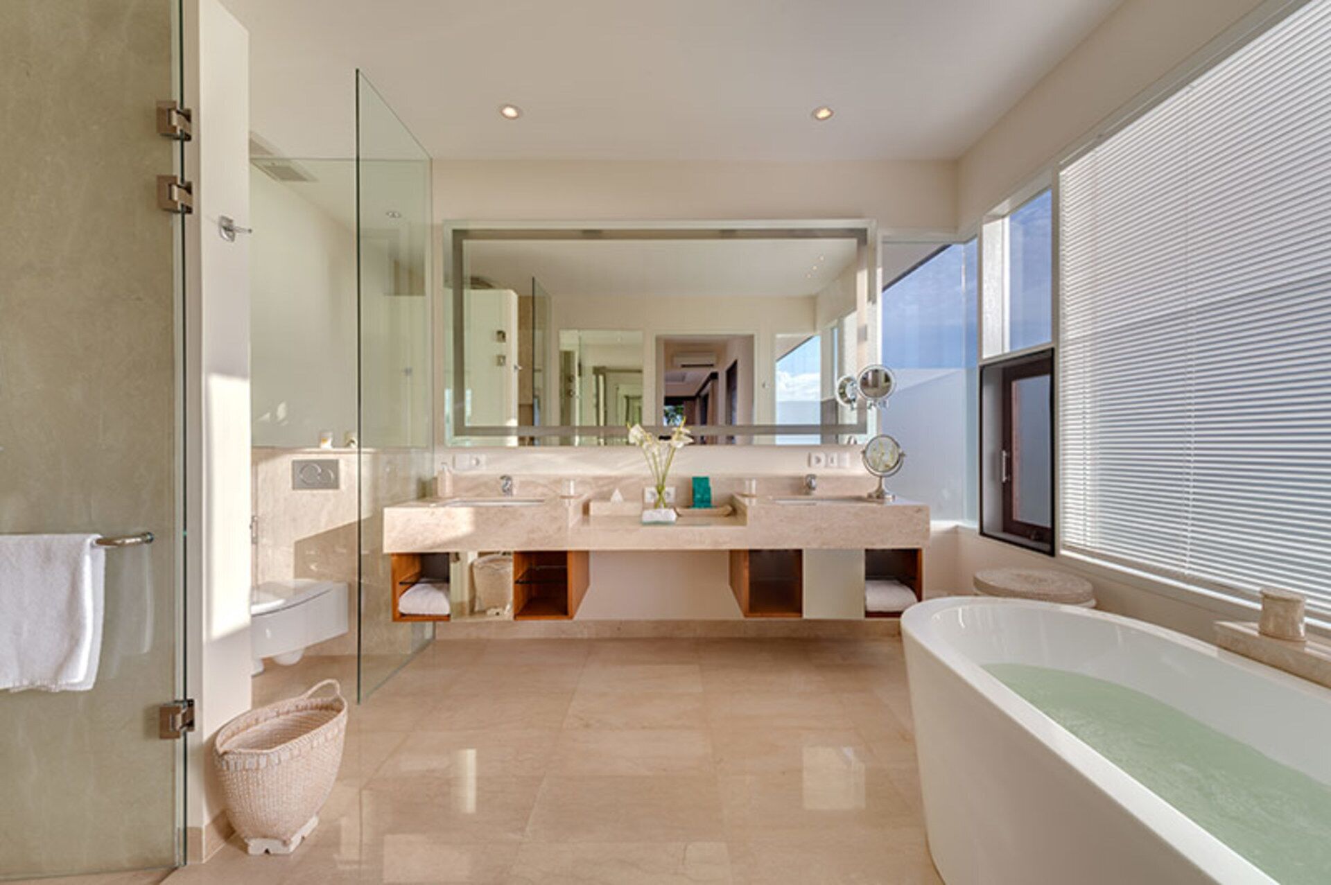 Un baño moderno con una bañera grande, cabina de ducha de vidrio y tocador con espejo.