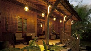 Eine hölzerne Veranda mit Treppe, Stühlen und hängenden Leuchten.