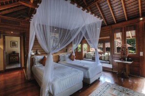 A room with two beds, a wooden ceiling, and a large window. - Serene luxury in lush gardens, Bali Villa 1124 (Bali)