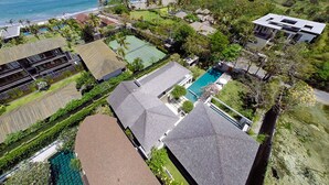 A residential area with a swimming pool, tennis court, and ocean view. - Tropical Breeze Ocean Views - Bali Villa 1128 (Bali)