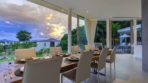 Comedor con mesa para cuatro, ventanas amplias y vistas a un paisaje montañoso.
