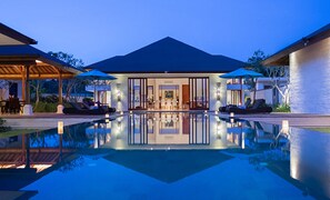 Une maison moderne dotée d’une piscine, d’un espace extérieur aménagé et d’un intérieur bien éclairé.