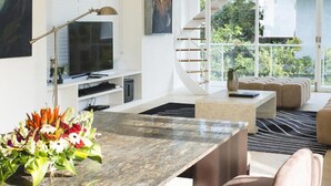 A modern living room with a large island, a staircase, and a balcony with plants. - Modern Beachside Escape with Private Pool – Bali Villa 1108 (Bali)