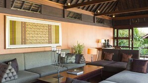 A modern living room with a sofa set, a coffee table, and a decorative wall piece.