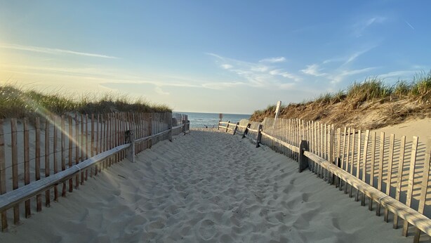A sandy beach pathway flanked by wooden fences and grassy dunes leading to the sea. - Modern Cape, Private Heated Salt Water Pool,  Minutes to Beaches/Golf/Lakes (Brewster)