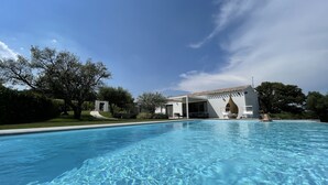 A clear swimming pool with a white building in the background.