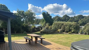 A wooden deck with picnic tables and a hot tub. - Alpine Bach with spa and separate games room. (Ohakune)