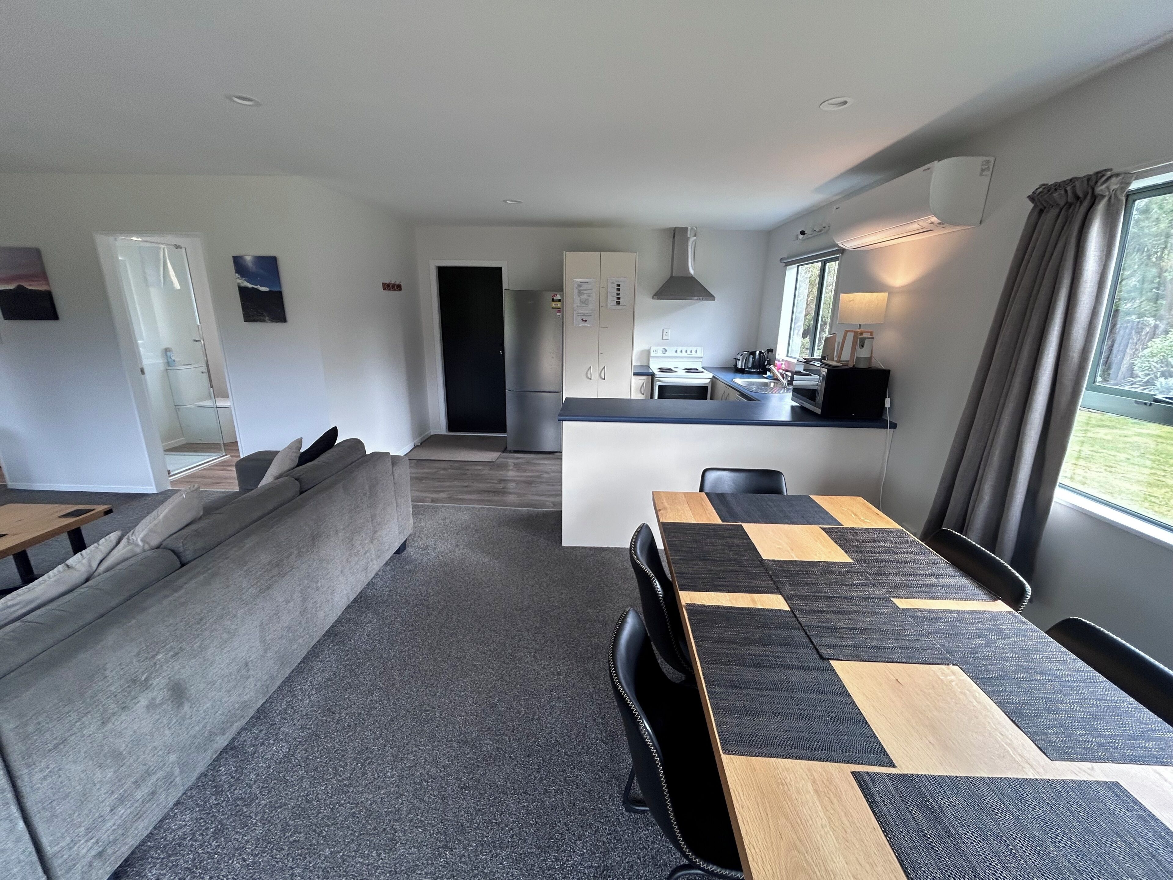A modern apartment with a living area, kitchen, and dining space.