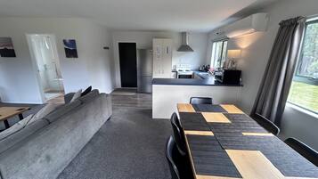 A modern apartment with a living area, kitchen, and dining space.