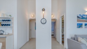 A modern interior with a central hallway, a wall-mounted clock, and a sofa. - Two bedroom apartment with wonderful sea view (Mimice)