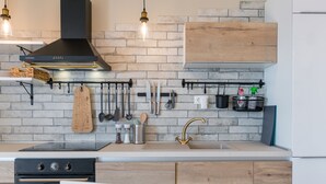 A modern kitchen with a brick backsplash, wooden cabinets, and a stainless steel range hood. - Two bedroom apartment with wonderful sea view (Mimice)