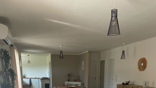 Una sala moderna con un sofá modular, una mesa de centro de madera e iluminación colgante.