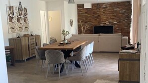 Un amplio espacio de estar con una mesa de comedor, sillas, un sofá y un televisor.