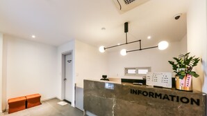 A reception desk labeled "INFORMATION" with a modern design, a plant, and a bench in a clean, well-lit lobby area. - Hotel N7 Daejeon Bus Terminal (Daejeon)