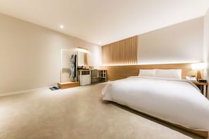 A modern hotel room with a large bed, a bedside table with a lamp, a built-in wardrobe, and a mirror. - Hotel N7 Daejeon Bus Terminal (Daejeon)