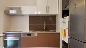 A modern kitchen with stainless steel appliances, a dishwasher, and a built-in oven.