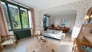 En stue med sofa, stole, sofabord og et spiseområde med bord og stole.