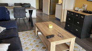 Un salon moderne avec un canapé, une table basse et un téléviseur.