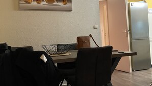 Un coin repas avec une table, des chaises et un tableau accroché au mur.