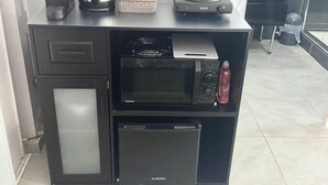 Une petite cuisine équipée d’un four à micro-ondes, d’un grille-pain et d’une machine à café.