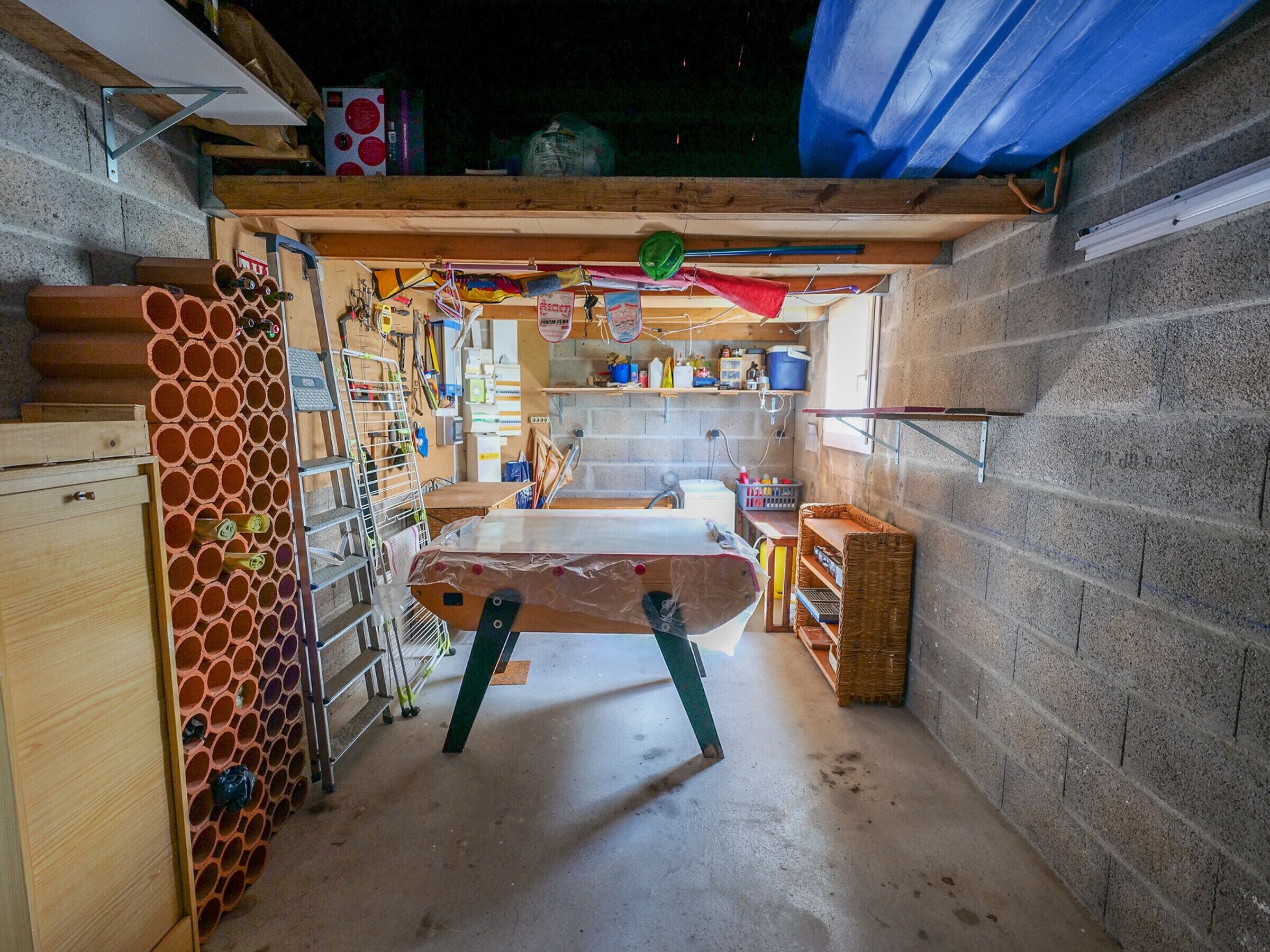 Cocina compacta con lavamanos, armarios de madera y suelo de concreto.