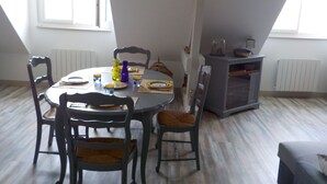 Un comedor con una mesa redonda, sillas y un mueble bajo.