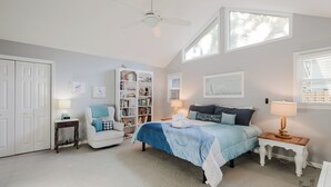 A bedroom with a bed, a bookshelf, a desk, a chair, and a ceiling fan. - 14 Egret - Easy Sea, Near Beach and Coligny (Hilton Head Island)