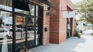 A brick building with a glass storefront and a sign reading "Cape Charles Distillery". - Peach Perfect Victorian Home with Gourmet Kitchen (Cape Charles)