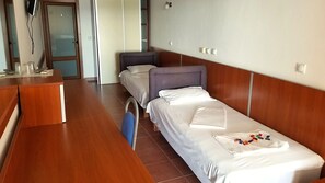 Two single beds and a desk with a mirror above.
