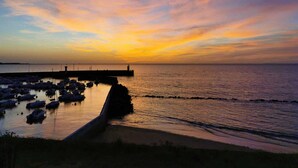 Ein Hafen mit Booten, die an einer Mole im Sonnenuntergang liegen.