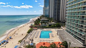 Un hôtel de grande hauteur doté d’une piscine, d’une plage et offrant une vue sur l’océan.