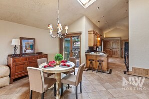 A spacious kitchen with wooden cabinets, a dining area with a round table and chairs, and a chandelier. - Luxury Home—Fireplaces, Hot Tub, Fire Pit, Soaking Tub & Stunning Views for Ultimate Relaxation! (Hayden)