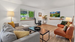 Un salon moderne comprenant un canapé, un fauteuil, une table basse et une cheminée.