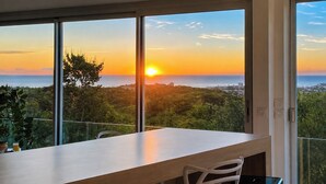 A modern room with large windows, a wooden table, and a chair.