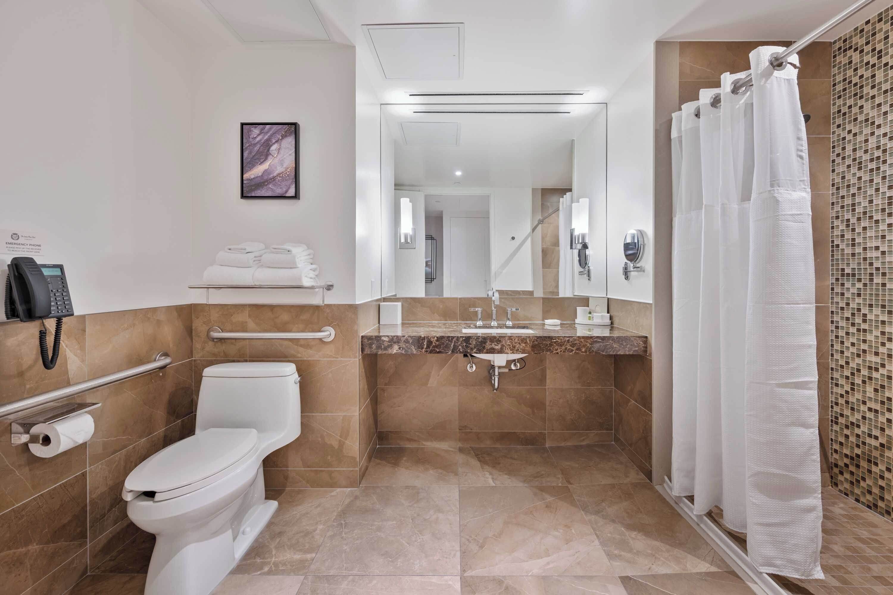 Een moderne badkamer met toilet, wastafel en douchehoek.
