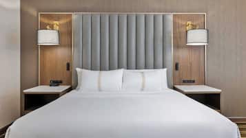 Una habitación de hotel con una cama grande, dos mesitas de noche y dos lámparas de pared.