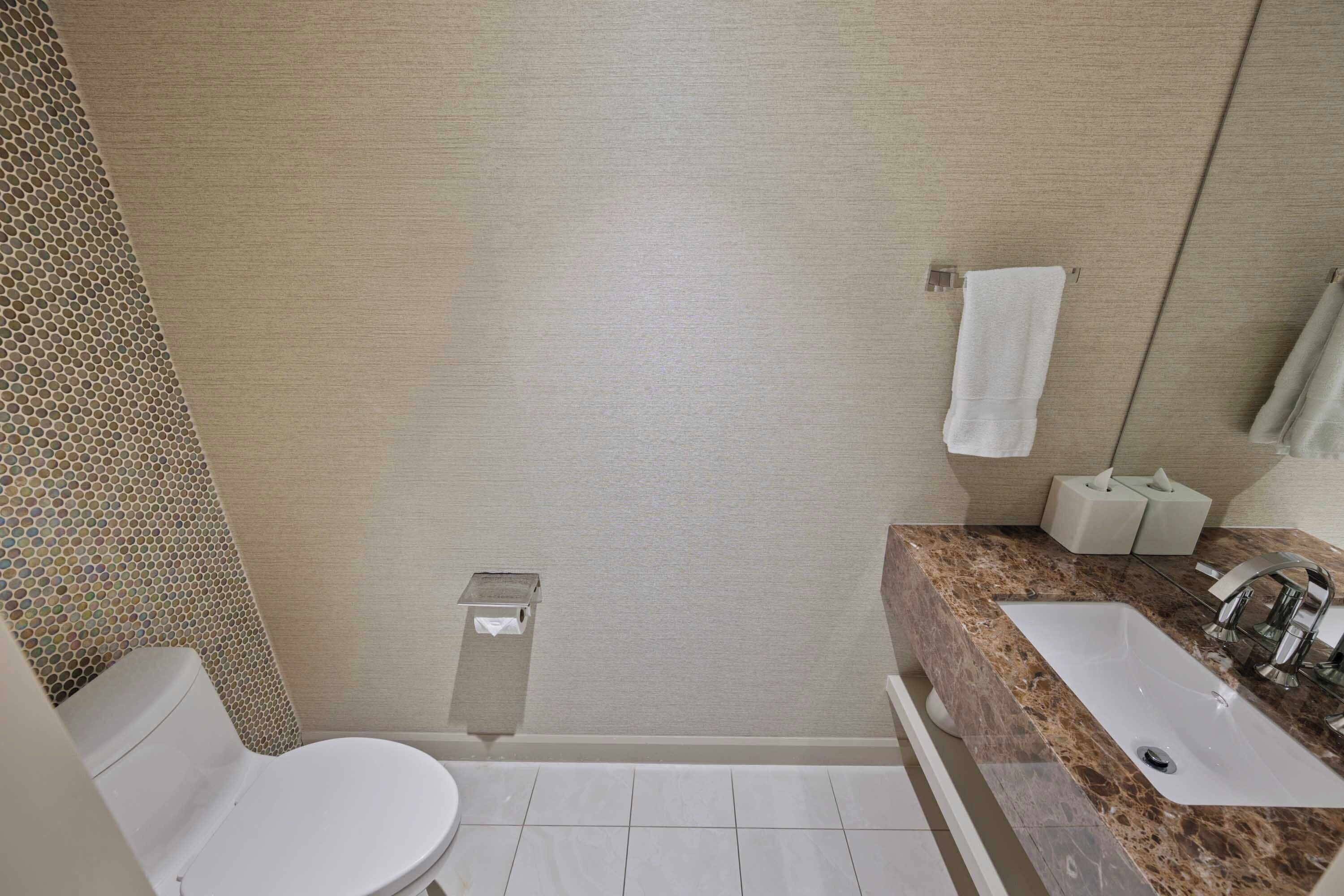 Un baño con inodoro, lavabo y ducha.