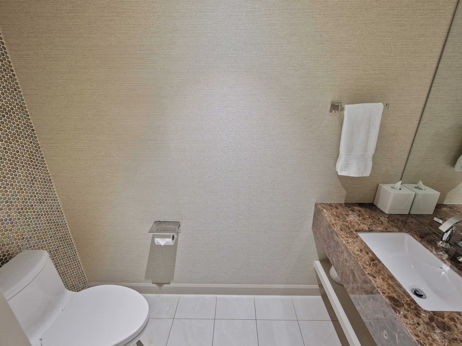 A bathroom with a toilet, sink, and shower.