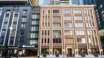 A hotel with a classic facade, featuring large windows and a prominent sign for The Sutton Place Hotel.