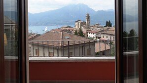 Un balcone con vista su una città, un lago e montagne.