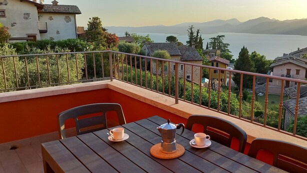 Un balcone con un tavolo, due sedie e una macchina per il caffè.