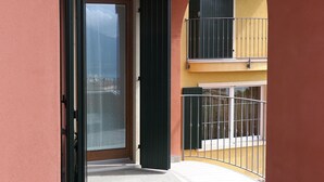 Un'apertura che dà su un balcone con vista sul mare, un pavimento piastrellato e una ringhiera.