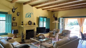 Una sala de estar acogedora con chimenea, asientos cómodos y decoración mural.