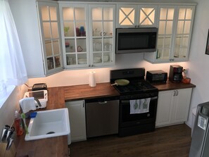 A kitchen with white cabinets, a microwave, a stove, a toaster, and a coffee maker. - BEACH BLOCK - NEW LUXURY CASINO (Atlantic City)