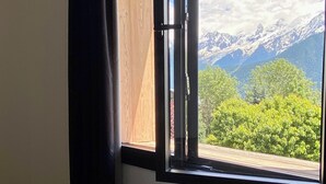 A room with a large window offering a mountain view. - 🏔 Symphonie des Cimes - fully renovated 2024 | Rando & Tennis  (Passy)