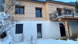 A modern two-story building with a wooden facade and a balcony with a metal railing. - 🏔 Symphonie des Cimes - fully renovated 2024 | Rando & Tennis  (Passy)