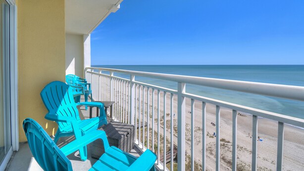 A balcony with turquoise chairs and a view of the beach. - Camelot By the Sea 1111 - Remodeled Spring 2023 - 2 Bed/2 Bath (Myrtle Beach)